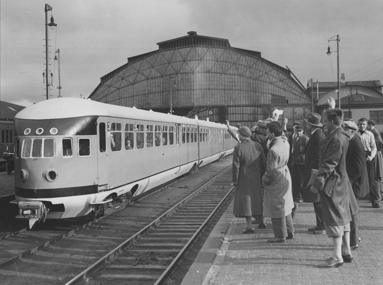 Nieuwsgierigen zwaaien op 1 mei 1934 de nieuwe dieseltrein uit op Amsterdam CS